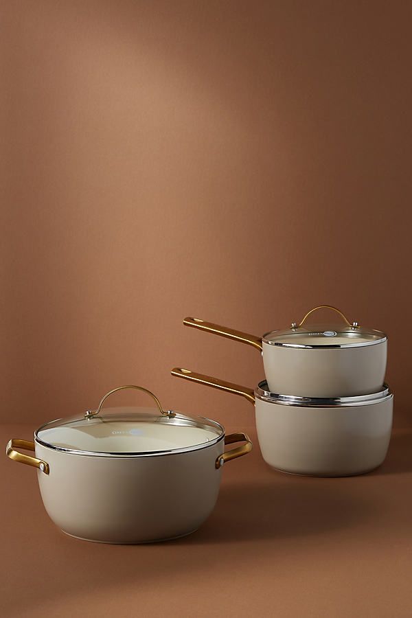 two white pans with gold handles on a brown background