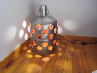 a lamp that is sitting on top of a wooden floor in front of a wall