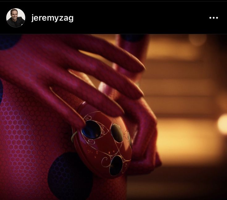 a close up of a person's hand holding a red object