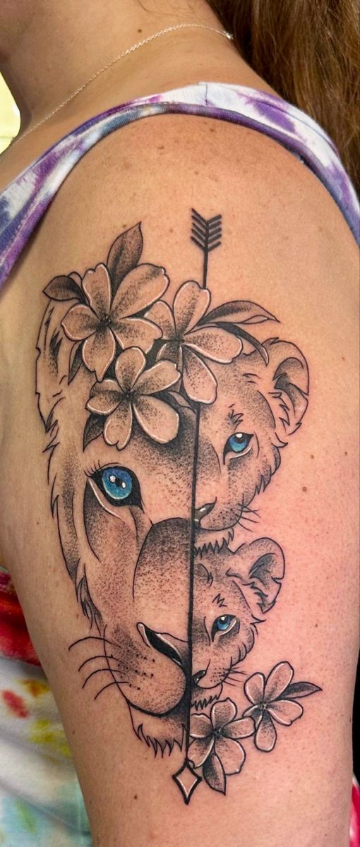 a woman with a tattoo on her shoulder has a lion and flower in the shape of a heart