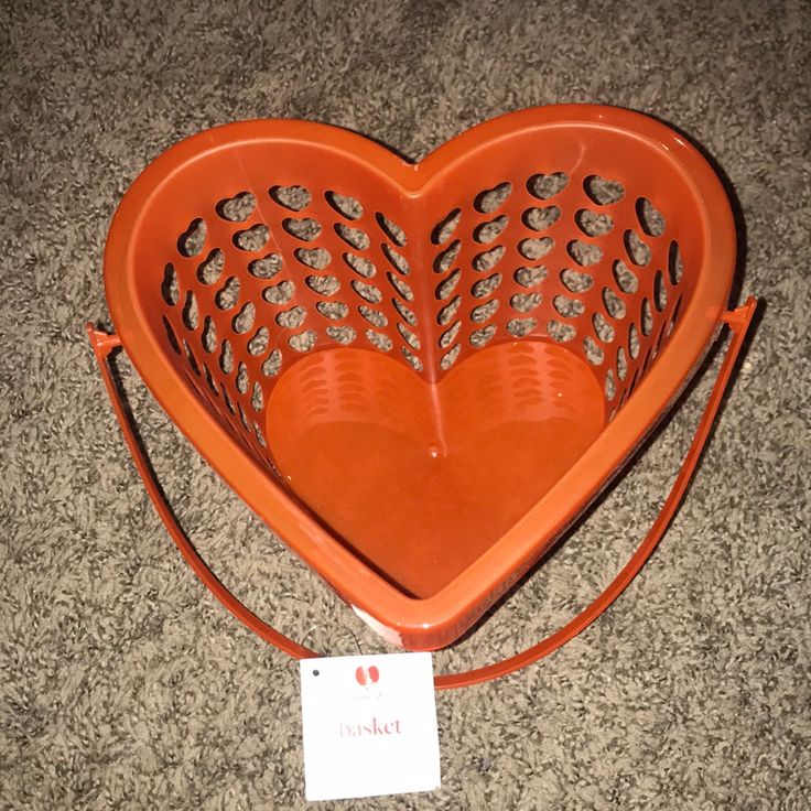 an orange heart shaped basket sitting on the floor with a price tag attached to it