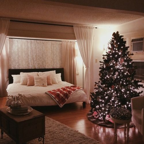 a bedroom with a christmas tree in the corner