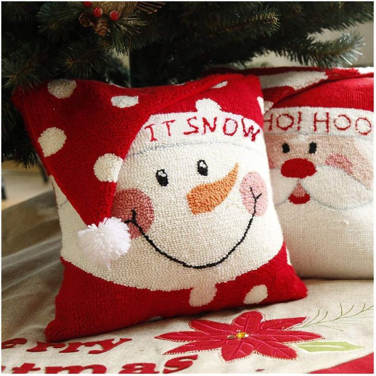 two christmas pillows sitting on top of a table