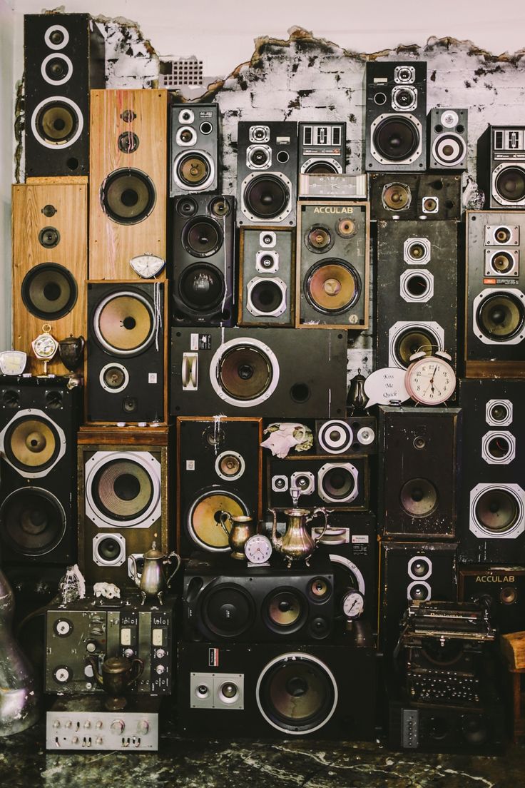 there are many speakers stacked on top of each other in front of a white wall