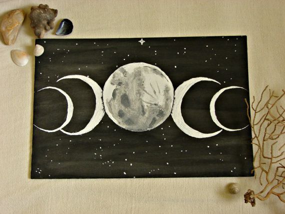 three phases of the moon painted on a black and white board with shells around it