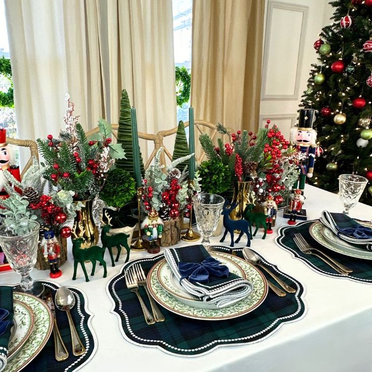 a table set for christmas dinner with plates and silverware