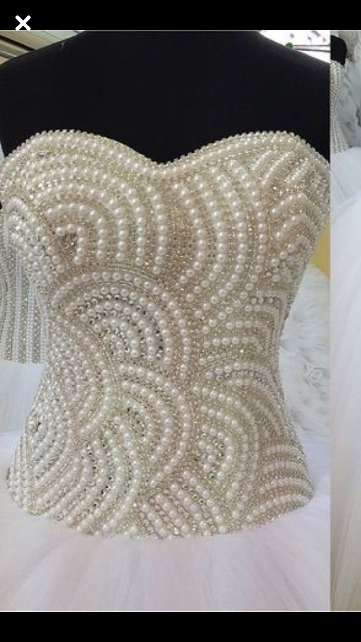 the back of a wedding dress with pearls on it