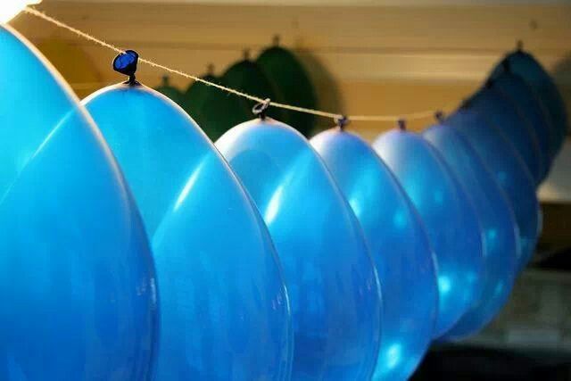 several blue balloons are hanging from a line