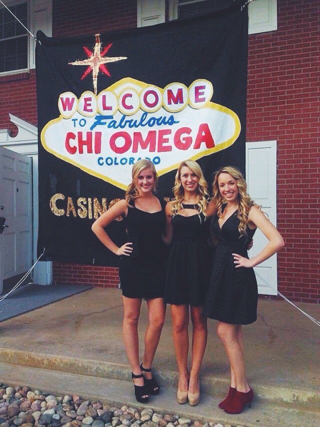 three beautiful young women standing next to each other in front of a sign that says welcome to fabulous chi omega