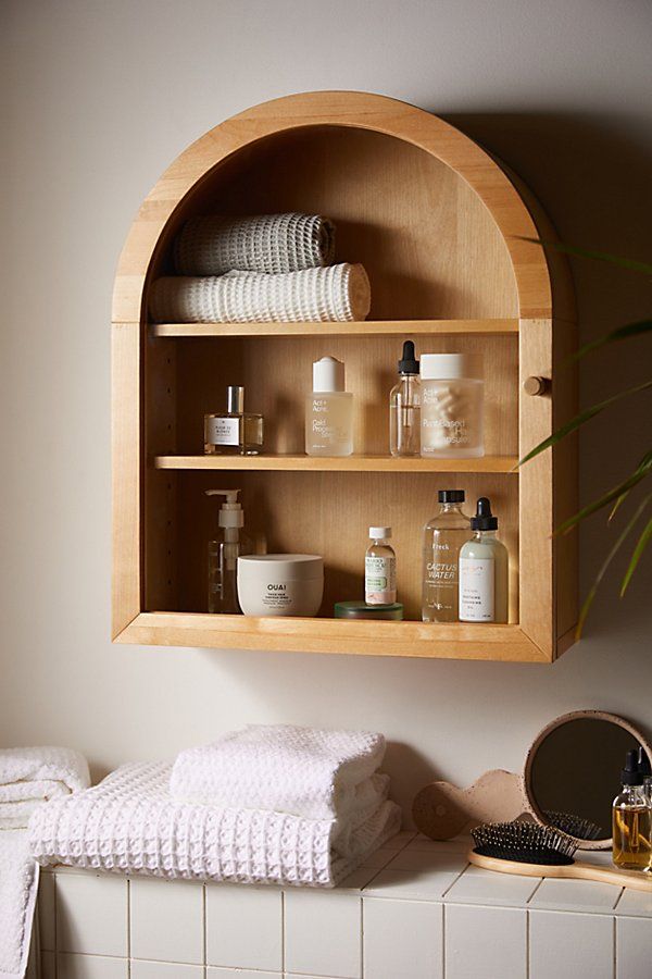 a wooden shelf filled with lots of personal care items on top of a white counter