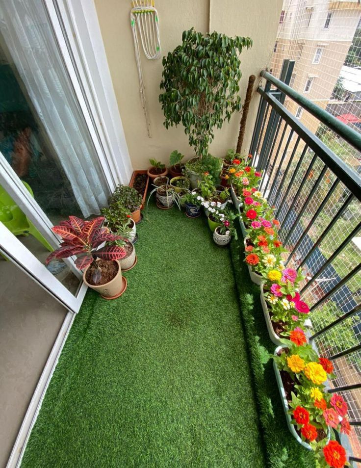 a balcony with potted plants on the grass