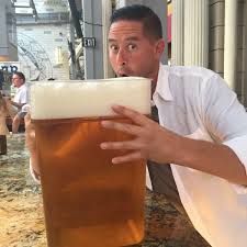 a man is drinking from a large mug