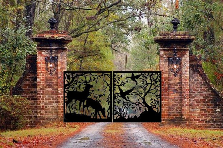 an iron gate with deer silhouettes on it in front of a brick wall and trees