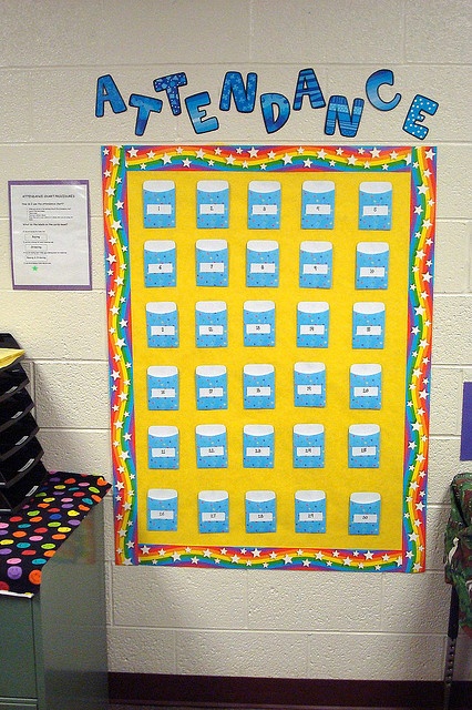 a bulletin board with the words attendance written on it in front of a classroom wall