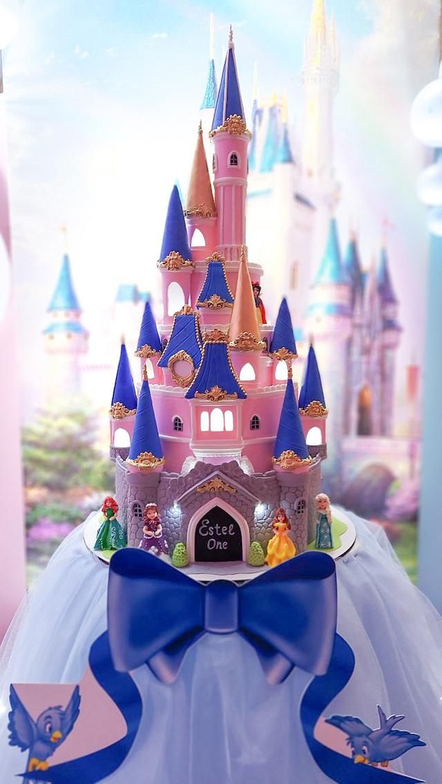 there is a cake made to look like a princess's castle with blue and pink turrets