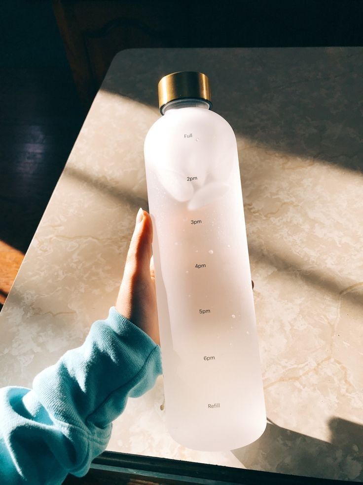 a person holding a water bottle on top of a table