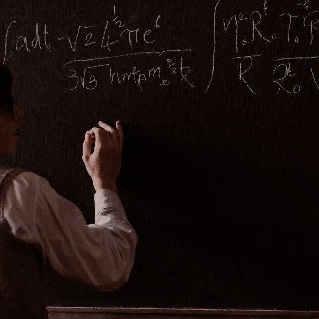 a man writing on a blackboard with chalk