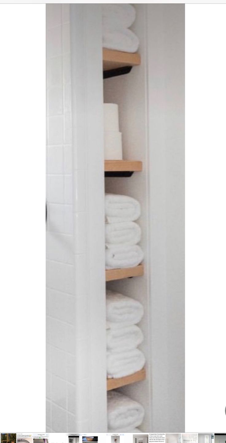 the shelves in this bathroom are filled with white towels