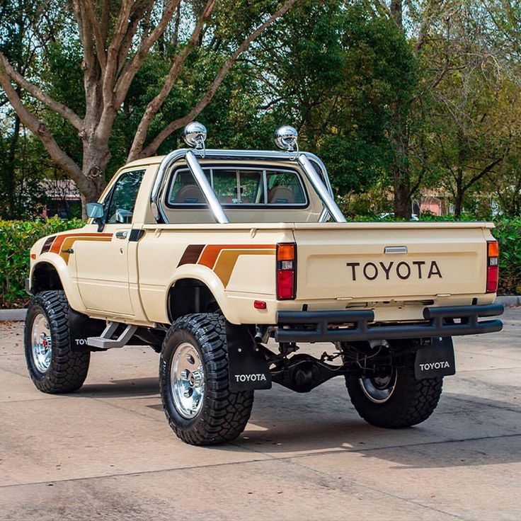 a tan toyota pickup truck parked next to a tree