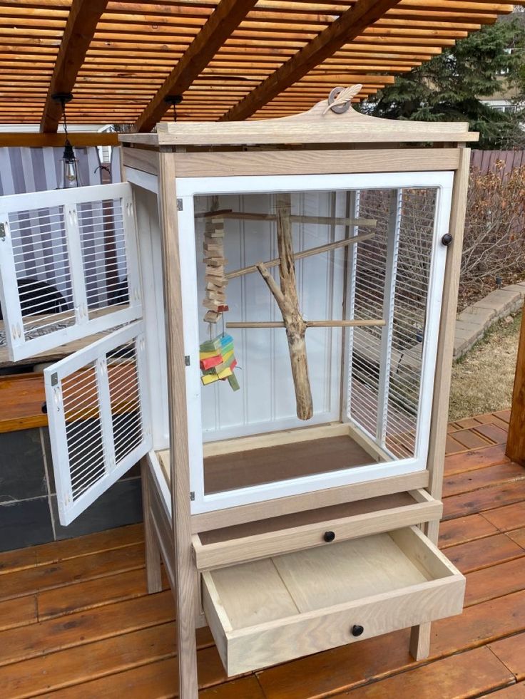 a bird cage sitting on top of a wooden floor