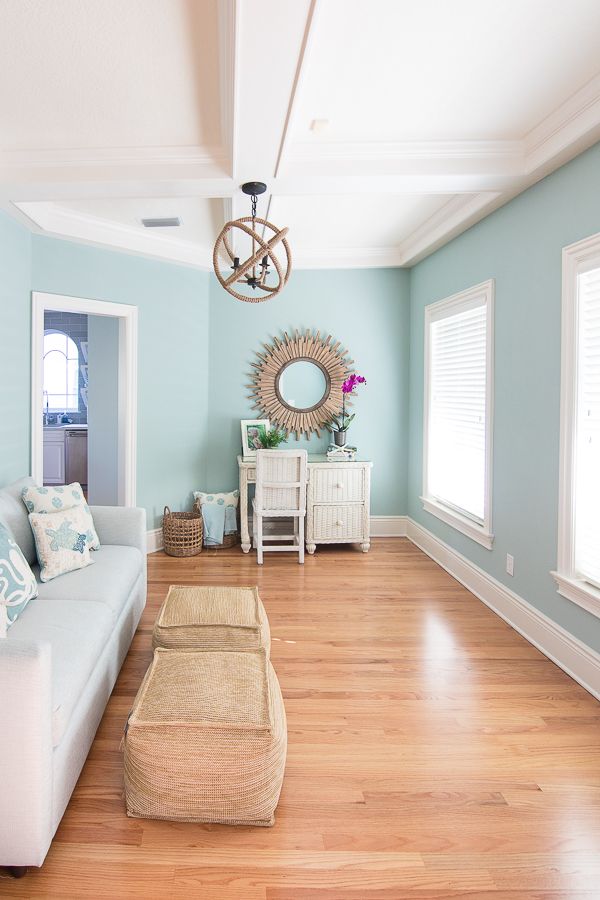 a living room with light blue walls and wood floors