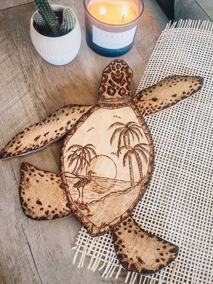 a wooden turtle sitting on top of a table next to a candle