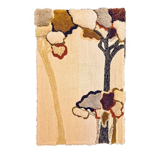 a rug with an image of a tree and flowers on the front, against a white background