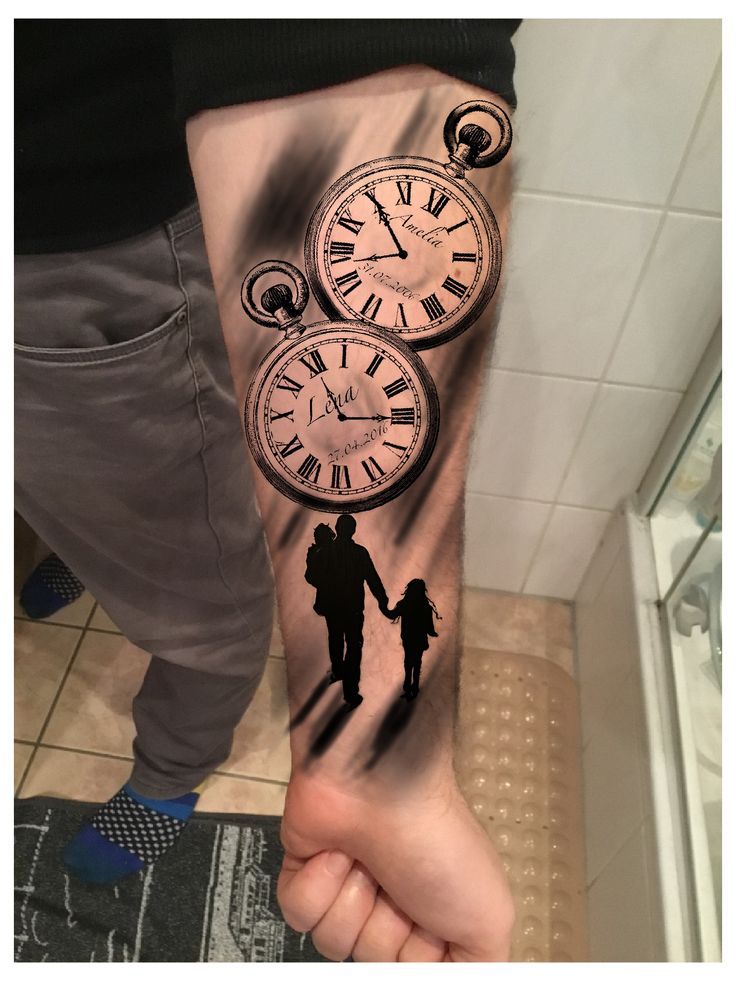 a person with a tattoo on their arm holding the hand of another person that is holding an analog clock