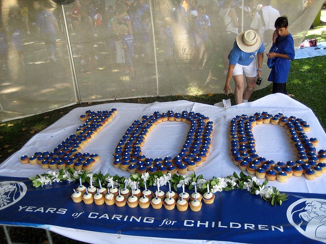 a blue and white table topped with lots of cupcakes