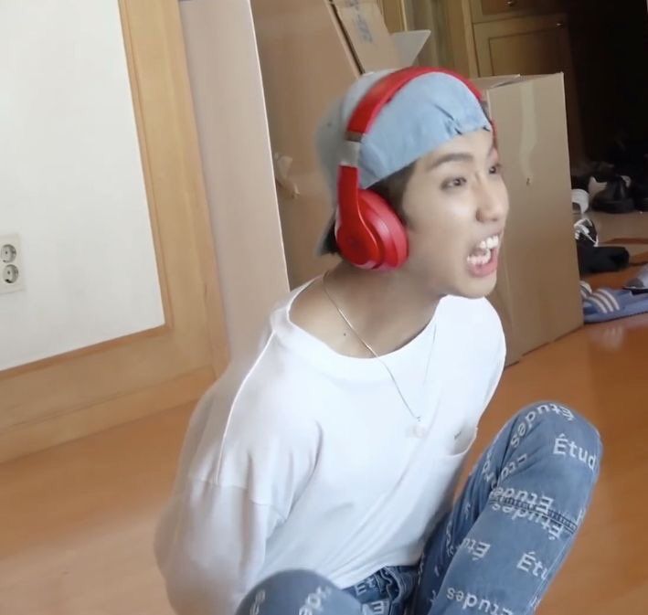 a young man sitting on the floor wearing headphones