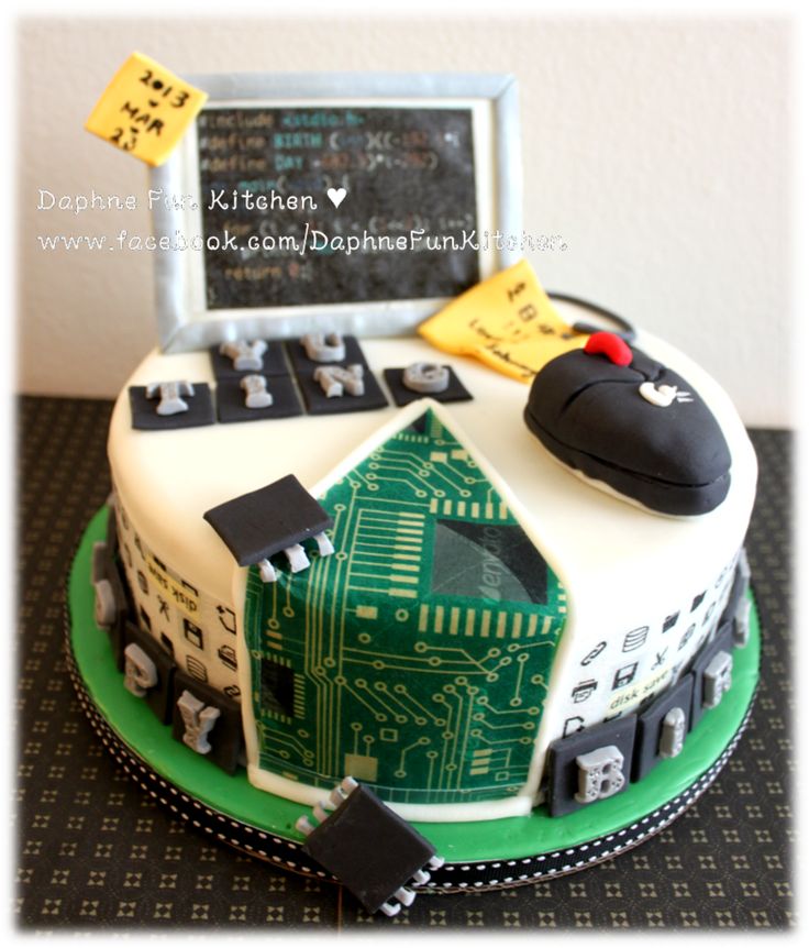 a cake with a computer on top and writing on the screen in front of it