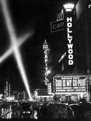 a black and white photo of the hollywood sign at night with light beams in the sky