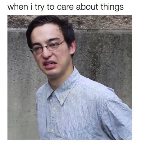 a man with glasses and a blue shirt is standing in front of a wall that says, when i try to care about things