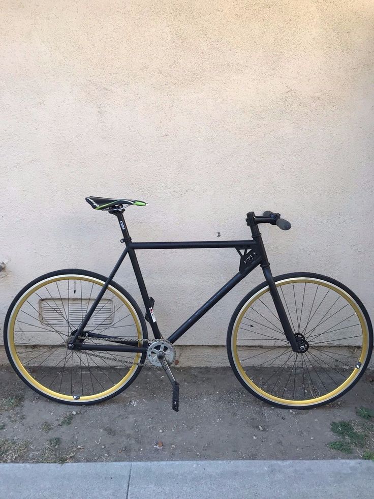 a black and yellow bike parked on the side of a street next to a building