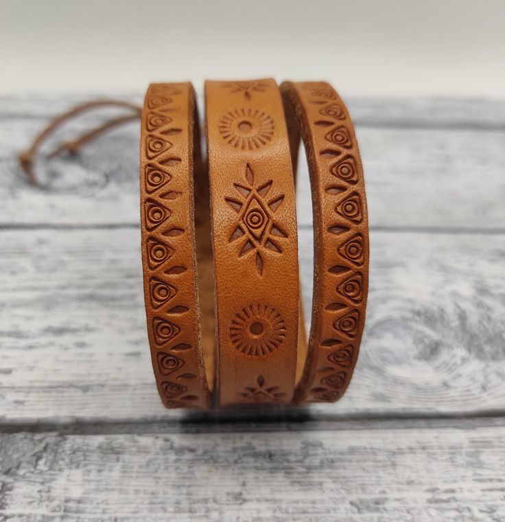 The leather bracelet with stamped pattern. Vegetable tanned leather. Brown Leather Wrap Bracelet For Festivals, Adjustable Stamped Leather Bohemian Bracelet, Brown Leather Bracelet With Wrist Strap For Festivals, Adjustable Hand Tooled Brown Leather Bracelet, Adjustable Hand-tooled Brown Leather Bracelet, Adjustable Engraved Leather Bracelet, Adjustable Engraved Bracelets For Festivals, Adjustable Stamped Brown Bracelets, Adjustable Stamped Brown Leather Bracelet