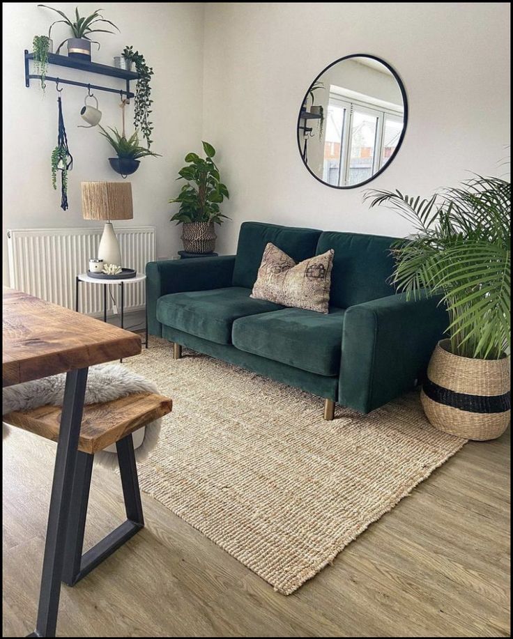 a living room with green couches and potted plants on the wall next to a wooden table