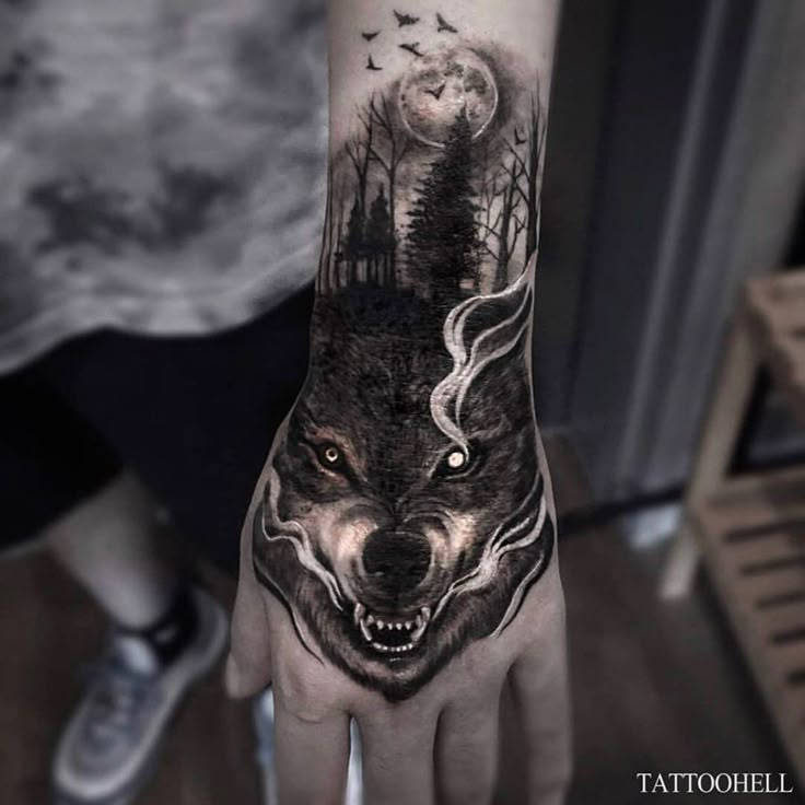 a person with a wolf tattoo on their hand