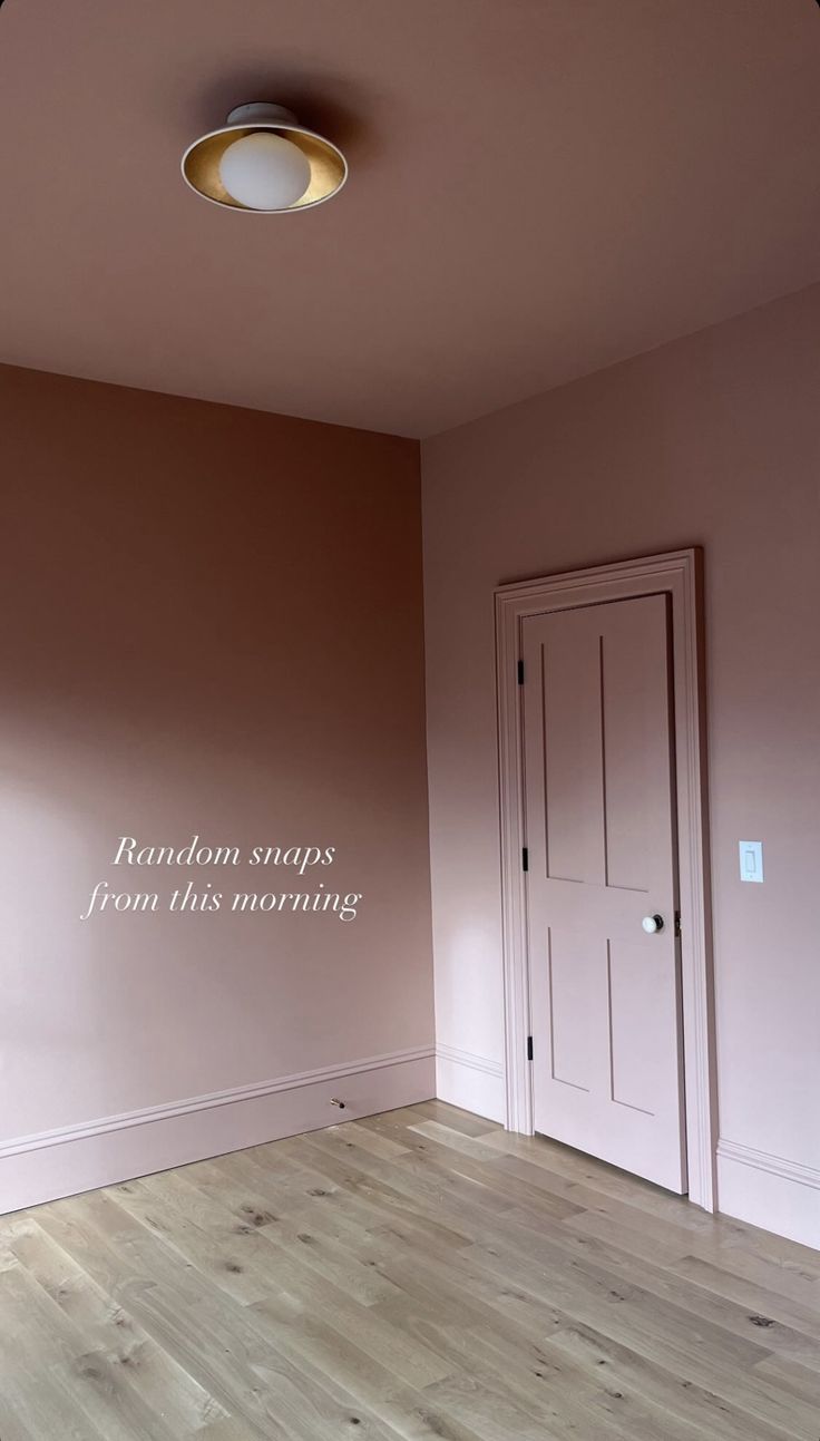 an empty room with pink walls and wood flooring in the center is a white round light fixture that reads random stops from this morning