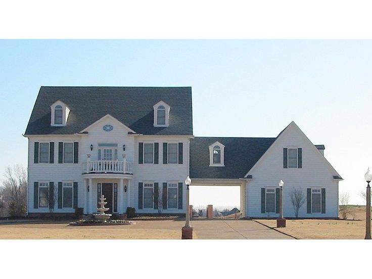 a large white house sitting on the side of a road