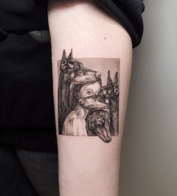 a woman's arm with a dog and cat tattoo on the left upper arm