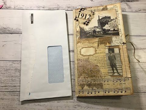 an old book with some paper on top of it next to a pen and scissors