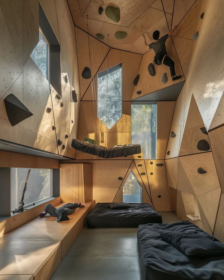 the interior of a bedroom with climbing walls and floor to ceiling windows is lit by sunlight