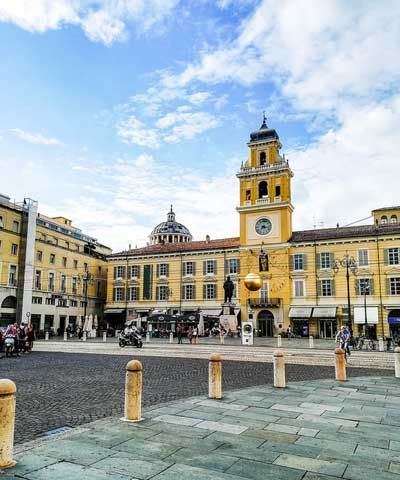 a large yellow building with a clock tower in the middle of it's courtyard