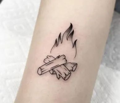 a black and white photo of a small tattoo on the arm that has a burning piece of wood in it