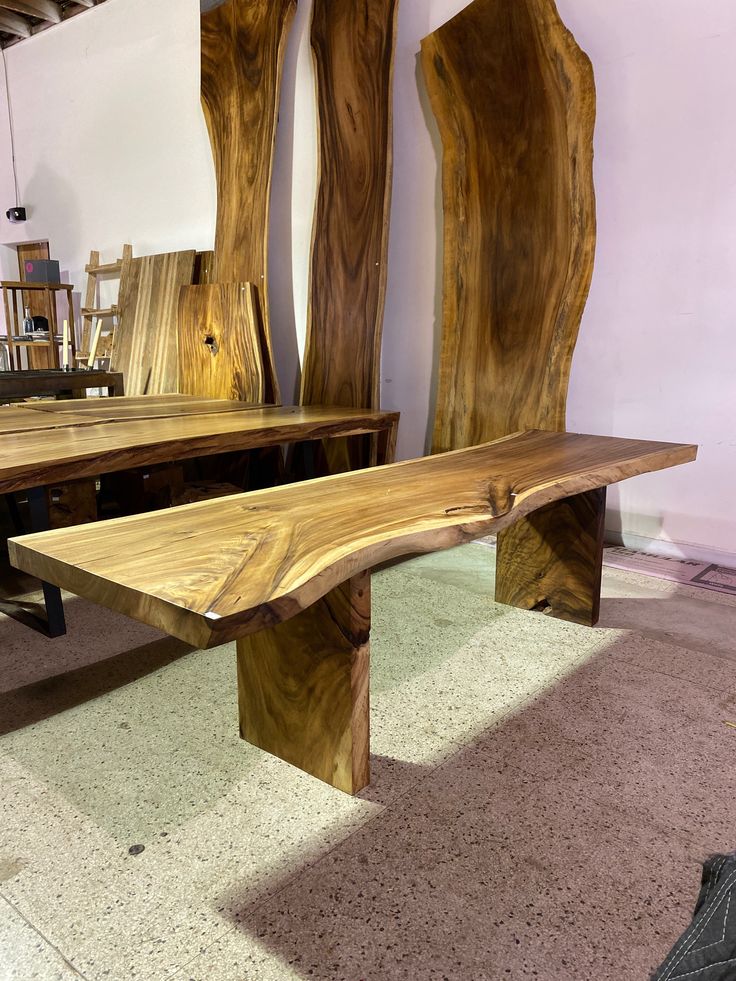 two wooden benches sitting next to each other on top of a carpeted floor in front of bookshelves