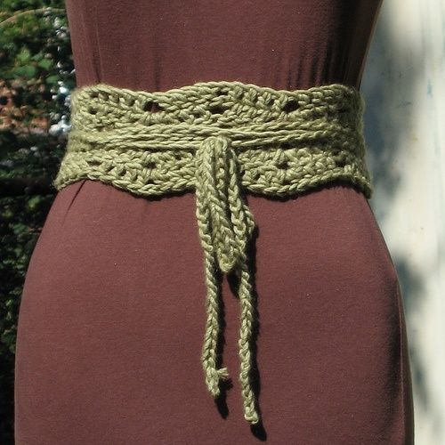 a woman wearing a brown dress with a green crochet belt on her waist