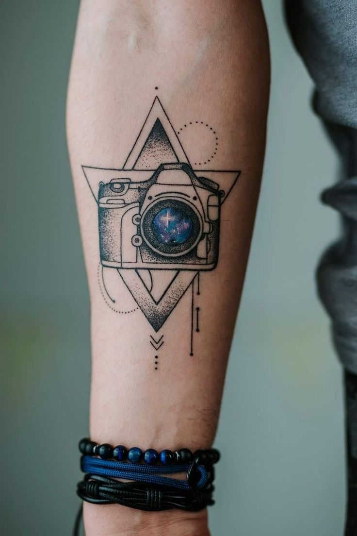 a person's arm with a tattoo on it and a camera in the middle