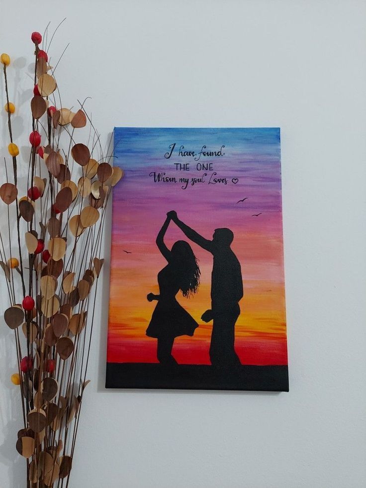 a painting on the wall next to a vase with flowers in it and a couple holding hands