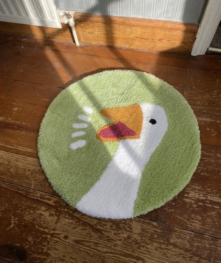 a green and white rug with a bird on it's face in front of a door