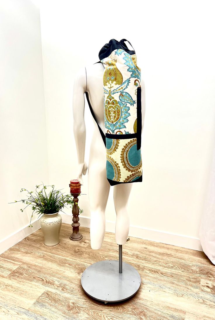 a mannequin wearing a colorful backpack on display in front of a white wall